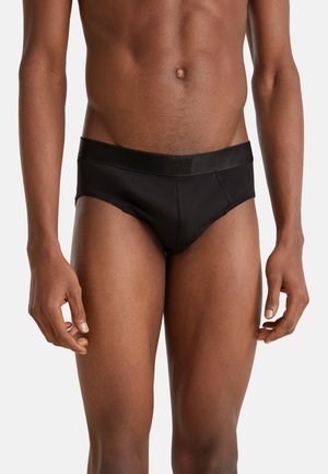 Slip nero realizzato in materiale morbido con una consistenza liscia. Presenta un elastico a contrasto nero con dettagli del logo.