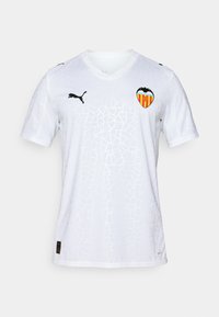 Hvit sportsdrakt med et geometrisk sprakkemønster, svart Puma-logo og Valencia CF-emblem i sterke farger på venstre bryst.