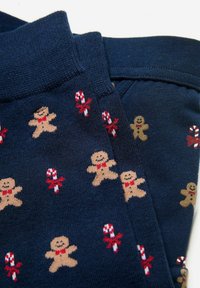 Tmavě modré ponožky se vzorem opakujících se perníčků a cukrových hůlek, s měkkou texturou a žebrovanými lemy pro pohodlí.