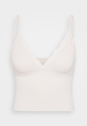 Light beige bralette with lace trim along the v-neckline and thin adjustable straps; made of soft, stretchy material with a fitted design.