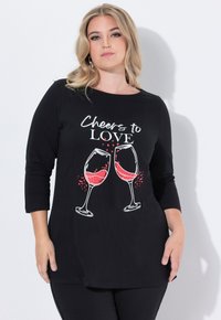 Czarna koszulka z długim rękawem z grafiką dwóch kieliszków wina wypełnionych czerwonym płynem oraz napisem "Toast za MIŁOŚĆ" nad nimi.