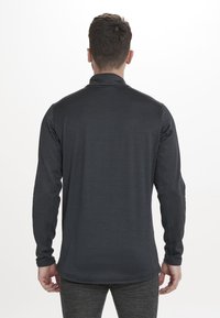 Langærmet performance-skjorte i mørkegrå stof med struktureret overflade, høj krave og tætsiddende design med buet kant.