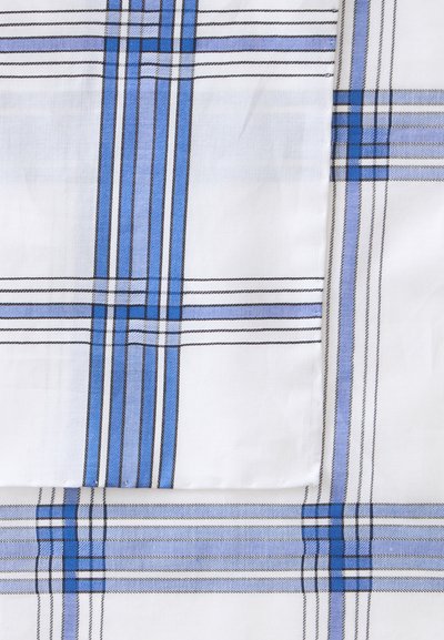 Tissu blanc avec des lignes à carreaux bleues et noires qui se chevauchent formant un motif à carreaux, montrant des plis et des couches du tissu.