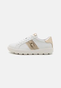 Sneakers bianchi con tomaia in pelle liscia, striscia e tallone dorati, e suola in gomma testurizzata. Presentano lacci piatti e un branding minimo.