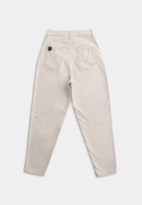 Beige katoenen broek met een rechte pasvorm, voorzien van twee achterzakken en een unieke patchdetail op het linkerbeen.
