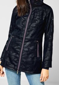 Veste camouflage noire avec fermeture éclair, accents violets, deux poches avant, tissu texturé, et coupe ajustée. Manches longues, style décontracté.