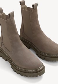 Bruna mocka Chelsea-boots med elastiska sidopaneler, texturerad gummisula, rund tå och kontrasterande sömnadsdetaljer.