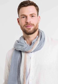 Kerge sall sinises, helesinis ja hallis värvitoonis, millel on narmastega ääred. Toetatuna kaela valge kraejoonega särgi kohale. Pehme tekstuur.