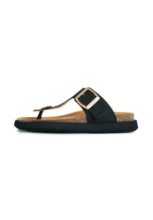 Black cork footbed sandal with toe loop and large gold buckle on wide strap, flat sole on white background.
