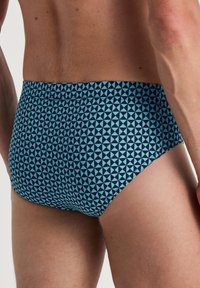 Heren zwemslips met een geometrisch patroon van lichtblauwe en donkerblauwe driehoeken, een gladde textuur, een middenhoogte ontwerp en een elastische tailleband.