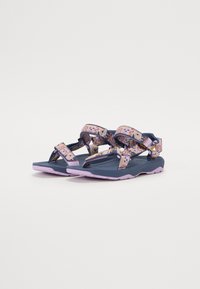 Blå sandaler med lilla gummisåler, med dekorative stoffstropper med geometriske mønstre og justerbare spenneholdere.