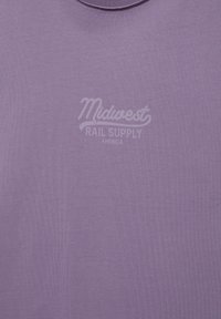 T-shirt violet avec un texte violet clair délavé « Midwest Rail Supply America » centré sur la poitrine.