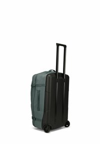 Valise à roulettes avec un extérieur en tissu vert foncé, une base en coque rigide noire, une poignée télescopique et des roues à roulement fluide.