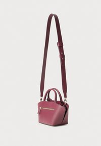 Piccola borsa a mano strutturata di colore viola con superficie testurizzata, due manici corti, una tasca frontale con zip e una tracolla lunga regolabile.