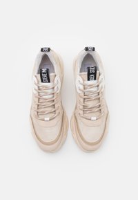 Sneaker beige con un mix di texture lisce e scamosciate, punta rotonda, design con lacci e marchio sulla linguetta e sul tallone.