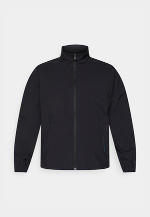 Veste noire zippée avec col montant, deux poches latérales, poignets élastiqués et texture de tissu lisse. Design simple, sans motifs visibles.