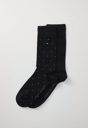 Schwarze Baumwollsocken mit kleinen grauen Punkten, gerippten Bündchen und dem "Tommy Hilfiger"-Logo in Grau an der Seite.