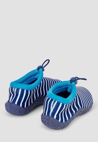 Scarpe da acqua a righe in blu e bianco, con un polsino elastico blu, linguetta e suola in gomma testurizzata per trazione e flessibilità.