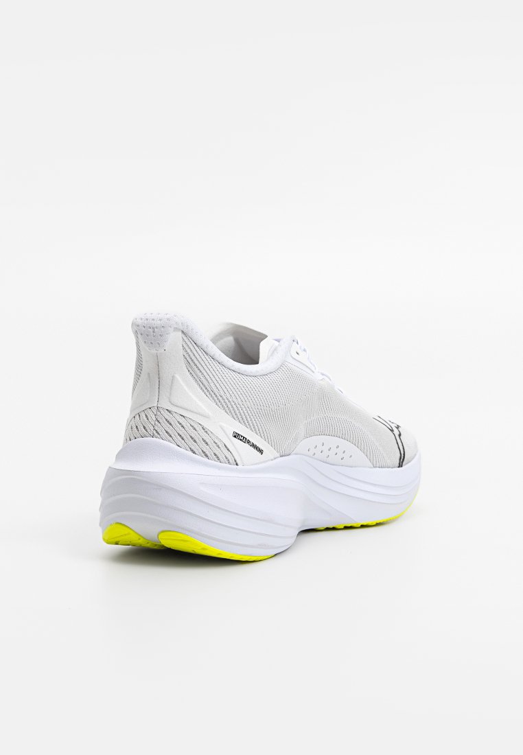 Zapatillas de running con parte superior de malla en blanco, acentos texturizados y una suela intermedia gruesa y blanca con una suela exterior de un amarillo brillante.