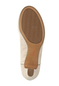 Semelle de chaussure beige avec un motif de caoutchouc texturé et une semelle intermédiaire lisse couleur tan. Logo de la marque "Clarks" imprimé en orange près du talon.