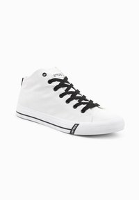 Sneaker alta bianca in tela, con lacci neri, dettagli neri, suola in gomma e un logo sul lato. Design classico.