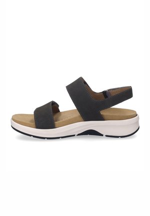 Black leather sandal with two adjustable straps, cushioned sole, and a white and black rubber outsole. Smooth texture and minimal design.