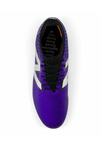Botín de fútbol morado con parte superior texturizada, cordones negros y acentos plateados. Presenta un diseño ajustado y un logo en el costado.