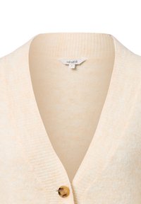 Lichtbeige cardigan met een v-hals, geribbelde textuur en een enkele gouden knoopsluiting aan de voorkant. Zachte gebreide stof. Maat S label zichtbaar.