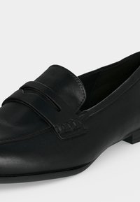 Mocassin homme en cuir noir avec couture moc toe et détail de bride, talon bas et finition lisse.