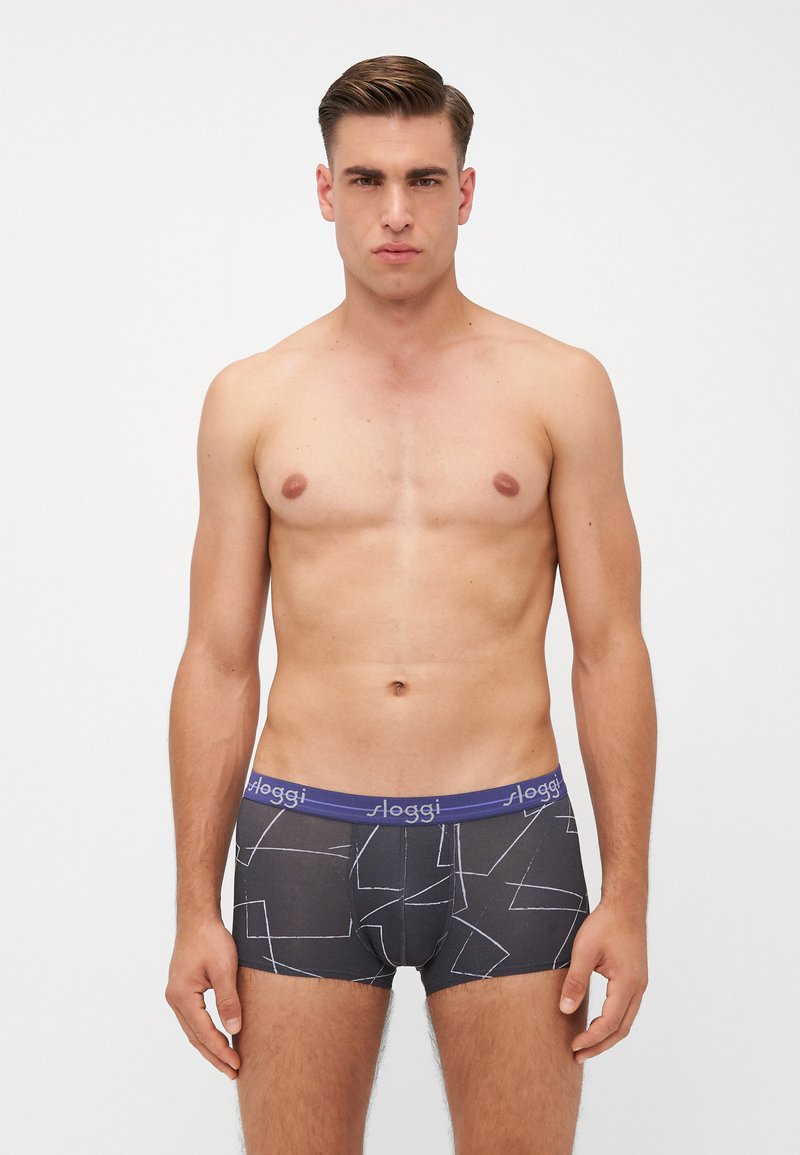 Men's boxers with a dark gray fabric featuring abstract white geometric patterns. Elastic waistband in purple with "Sloggi" branding.