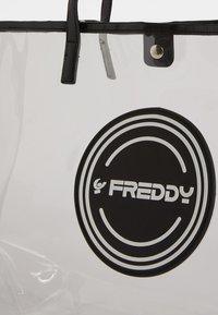 Borsa tote in PVC trasparente con manici in pelle sintetica nera e chiusura a scatto. Presenta un logo circolare in bianco e nero con cerchi concentrici.