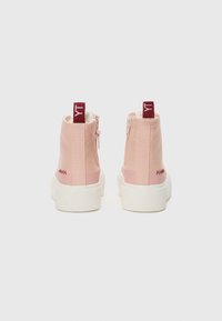 Ružové vysoké tenisky s hladkým textilným zvrškom, bielymi gumovými podrážkami, zipsom vzadu a kontrastnými marhuľovými pútkami.