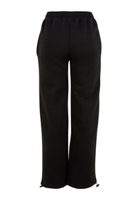 Schwarze, weit geschnittene Hose mit elastischem Bund und verstellbaren Kordeln am Saum, Rückansicht.