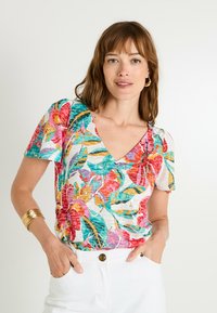Blusa de manga corta con estampado floral en colores vibrantes como rojo, verde y púrpura, con un diseño de cuello en V y textura ligera.