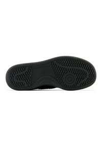 Schwarze Sneaker-Sohle aus strukturiertem Gummi mit einem gemusterten Profil. Die Struktur ist flach und breit.