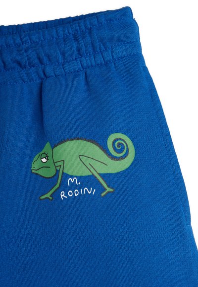 Blue cotton sweatpants feature a green chameleon graphic and "M. Rodini" text. Elastic waistband and soft texture provide comfort.