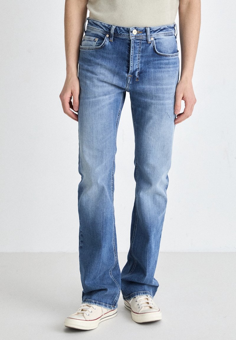 Jeans de mezclilla azul claro con un diseño de pierna recta, que cuentan con bolsillos frontales, cierre de botón y un desvanecimiento sutil para dar textura.