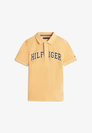 Żółta polo z krótkim rękawem, kołnierzykiem i plisą z guzikami, z napisem „HILFIGER” na piersi w czarnych i białych literach.
