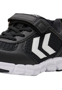 Svart sneakers med en strukturerad ovandel, vita accenter och justerbart rem. Har en vadderad vit sula med flexibla spår.