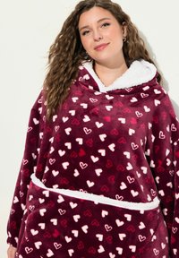 Plüschiger weinroter Kapuzen-Blanket-Sweatshirt mit weißem Fleece-Futter, das ein Muster aus kleinen weißen und pinken Herzen zeigt. Große Fronttasche.