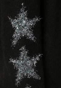 Tissu noir avec trois appliqués en étoile argentés scintillants au toucher duveteux, disposés verticalement avec des tailles variées.
