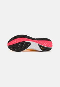 Suola di scarpa caratterizzata da un fondo in gomma nera testurizzata con accenti rosa e bianchi, che presenta un motivo a tassello triangolare per aderenza e trazione.
