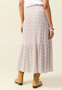 Gonna ankle-length con motivo floreale in tessuto leggero. Presenta una vita arricciata, design a strati, con motivi blu, arancioni e grigi.