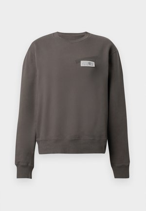 Felpa grigia in tessuto morbido, con scollo rotondo, maniche lunghe e taschino sul petto con dettaglio etichetta in bianco e nero.