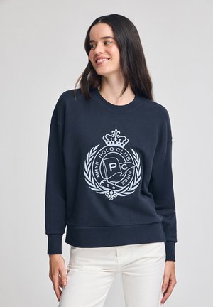 Dunkelblaues Sweatshirt aus Baumwolle mit einem großen grauen Logo mit Krone und Lorbeerdesign auf der Vorderseite sowie gerippten Bündchen.
