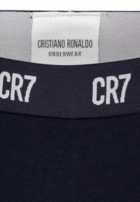 Marineblaue Unterwäsche mit einer weichen Textur, einem breiten elastischen Bund mit dem weißen Schriftzug "CR7" und einem Markenetikett mit der Aufschrift "Cristiano Ronaldo Underwear."