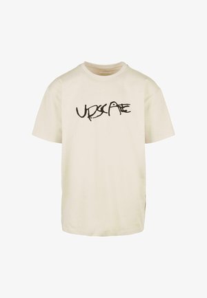 Krēmkrāsas kokvilnas T-krekls ar īsām piedurknēm un apaļu kakla izgriezumu, priekšpusē ar melnu grafisko tekstu "UPSCALE".