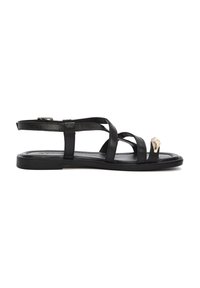 Sandali piatti in pelle nera con molteplici fasce incrociate, design elegante e un accento metallico sulla punta. Texture liscia e stile minimalista.