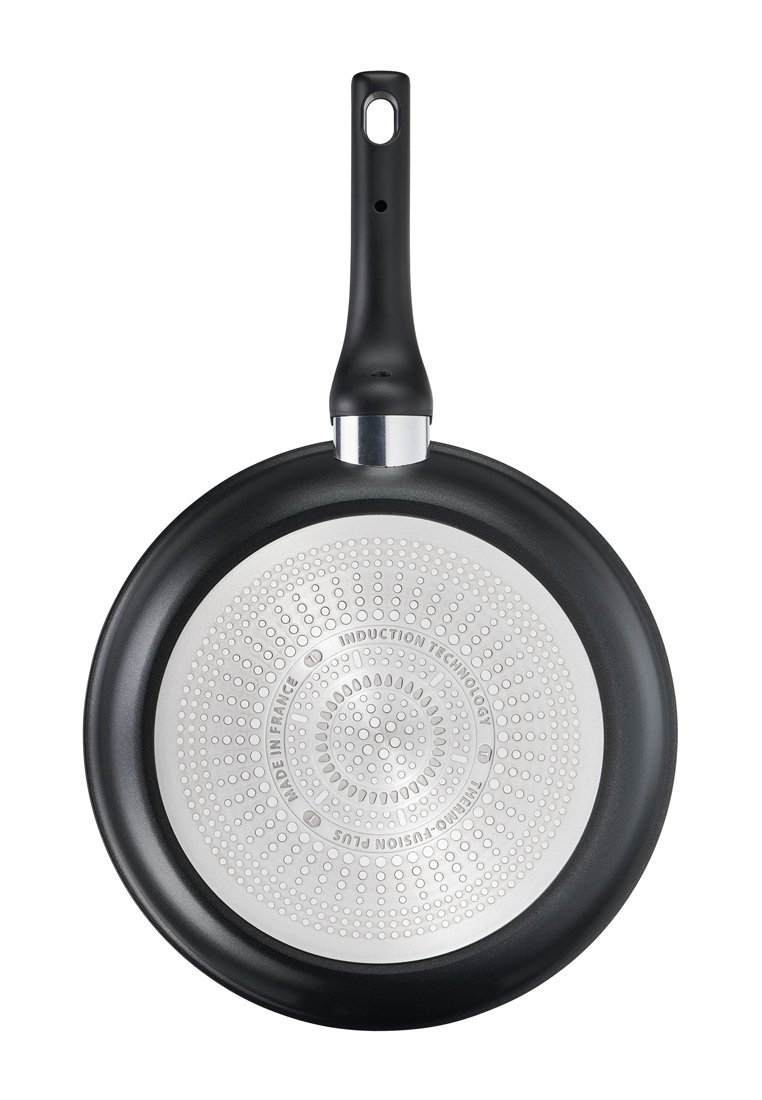 Schwarze Bratpfanne mit einer antihaftbeschichteten Oberfläche, silbernem Induktionsboden und einem runden Griff mit einem Hängeloch; strukturierter Boden mit kreisförmigen Mustern.
