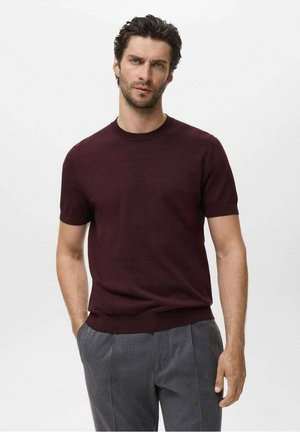 Burgundy short-sleeve knit sweater with a round neckline and ribbed cuffs, paired with gray tailored trousers. Smooth texture, minimalist design.